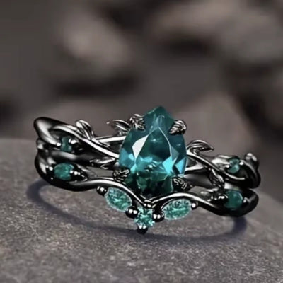 Anello di Lusso con Pietra Centrale e Dettagli Floreali – Montatura Nera Elegante