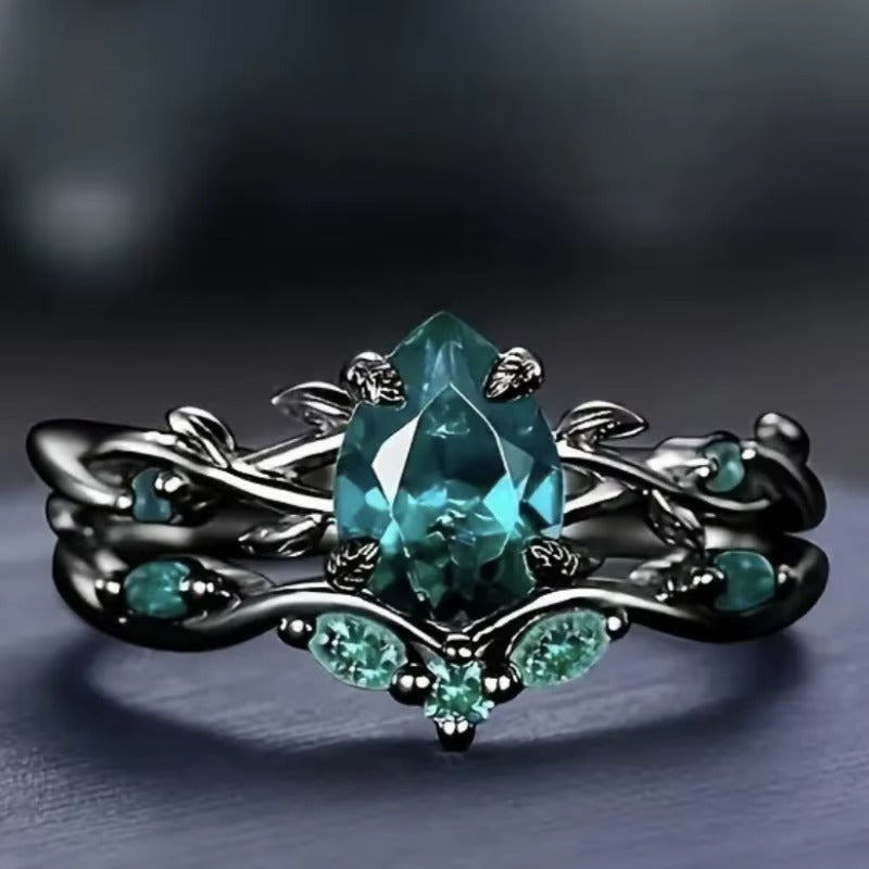 Anello di Lusso con Pietra Centrale e Dettagli Floreali – Montatura Nera Elegante