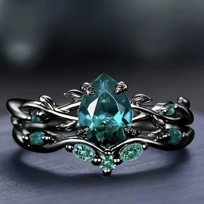 Anello di Lusso con Pietra Centrale e Dettagli Floreali – Montatura Nera Elegante